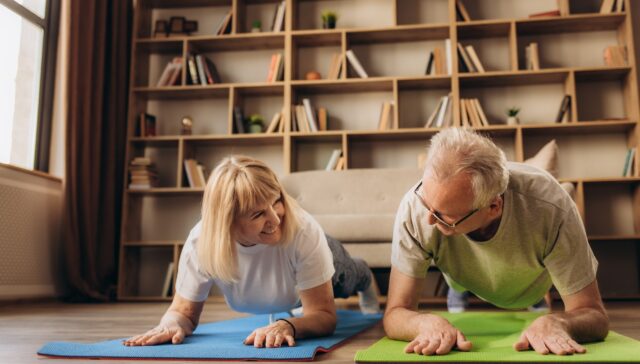 Portrait of a Senior Couple Doing Gymnastics and Yoga Stretching Exercises Together at Home on Sunny